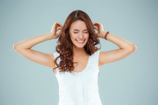 La mujer feliz en la pared gris