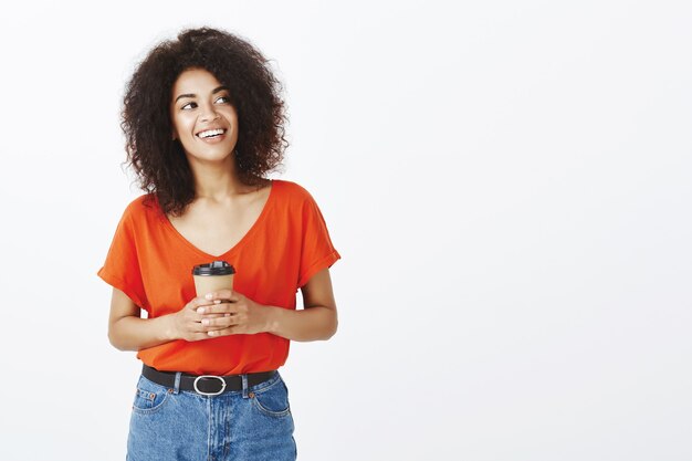 Mujer feliz con peinado afro posando en el estudio