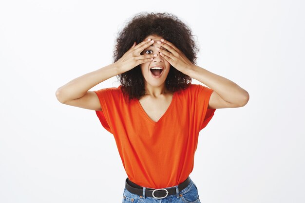 Mujer feliz con peinado afro posando en el estudio