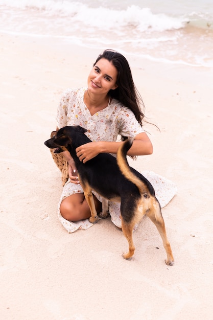 Mujer feliz con perro de playa