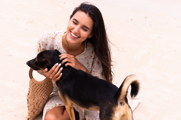 Mujer feliz con perro de playa