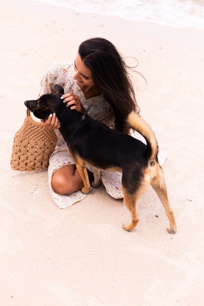 Mujer feliz con perro de playa