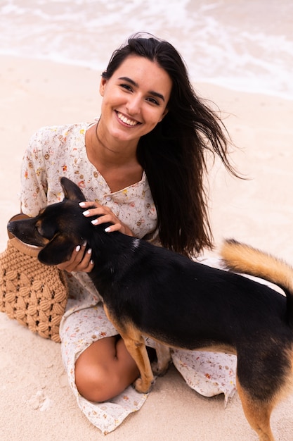 Mujer feliz con perro de playa