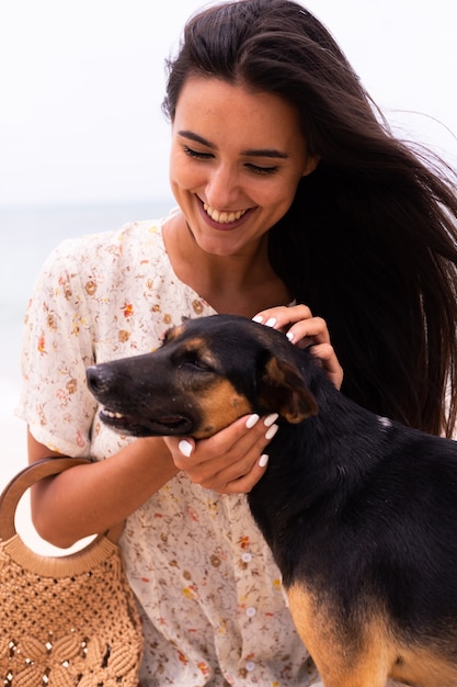 Mujer feliz con perro de playa