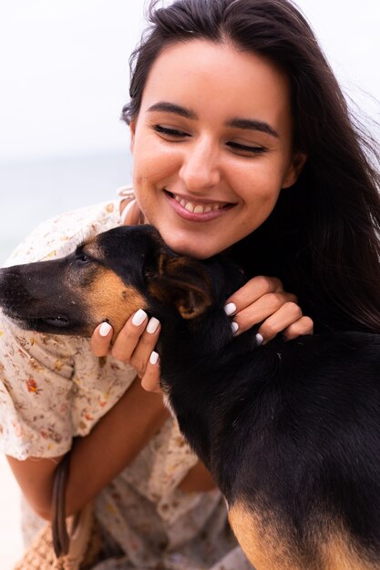 Mujer feliz con perro de playa