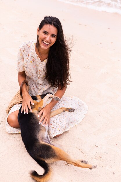 Mujer feliz con perro de playa