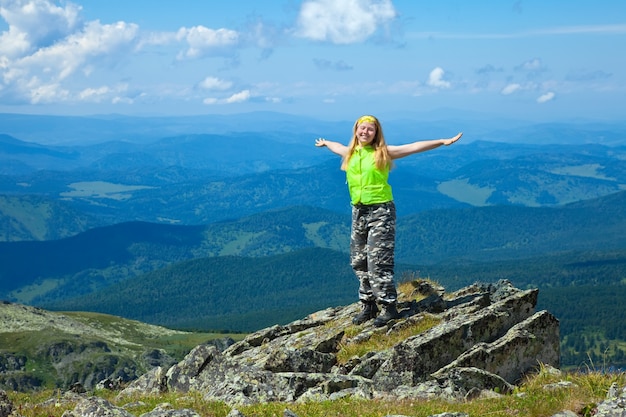 Mujer feliz en el pico de la montaña
