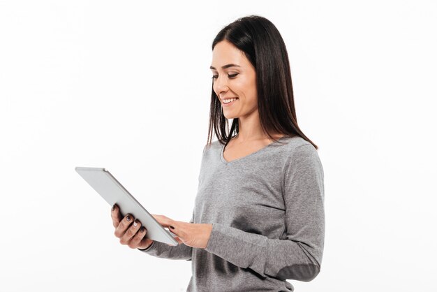 Mujer feliz de pie aislado con tablet PC.