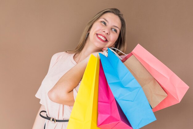 Mujer feliz de pie con coloridos bolsos de compras