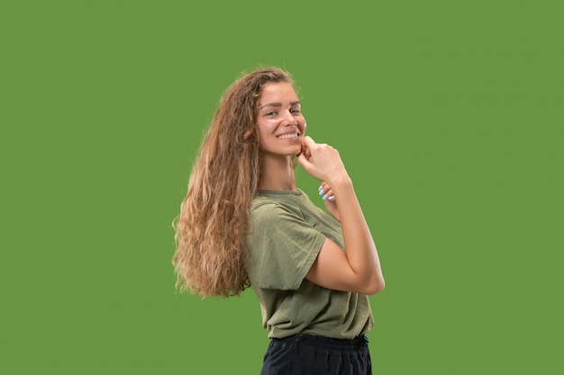 mujer feliz de pie y sonriendo contra el verde