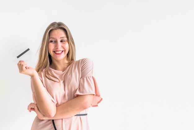 Mujer feliz de pie con tarjeta de crédito