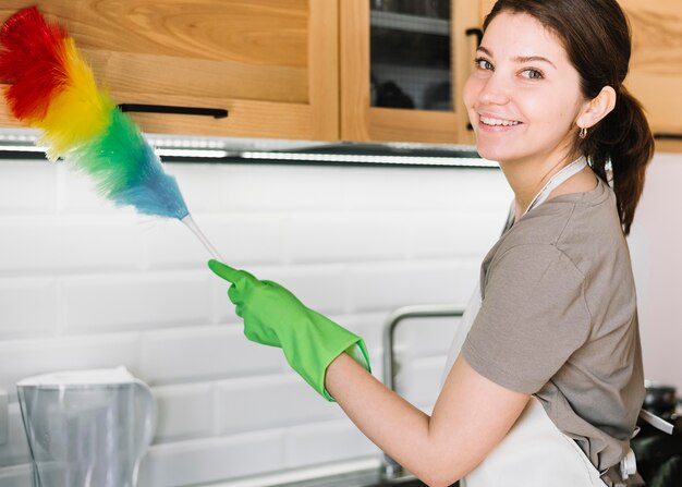 Mujer feliz con plumero esponjoso