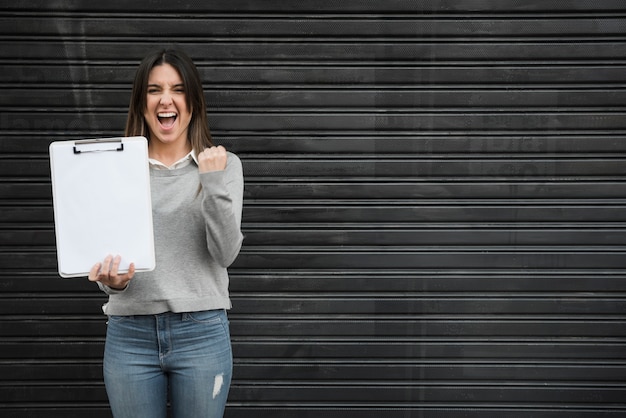 Mujer feliz con portapapeles en láminas perfiladas negras