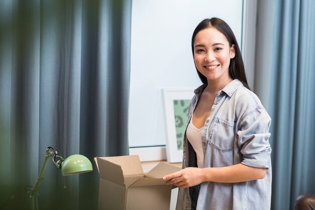 Mujer feliz posando con la caja que recibió después de ordenar en línea