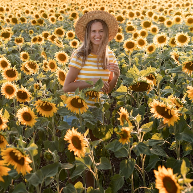 Foto gratuita mujer feliz posando en campo de girasol