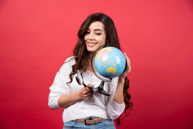 Mujer feliz posando con globo y lupa. Foto de alta calidad