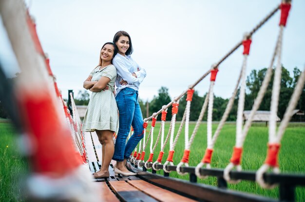 mujer feliz en un puente de madera en un prado verde en un día soleado