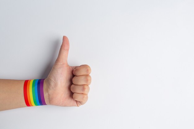 Mujer feliz con pulsera arcoiris LGBT.