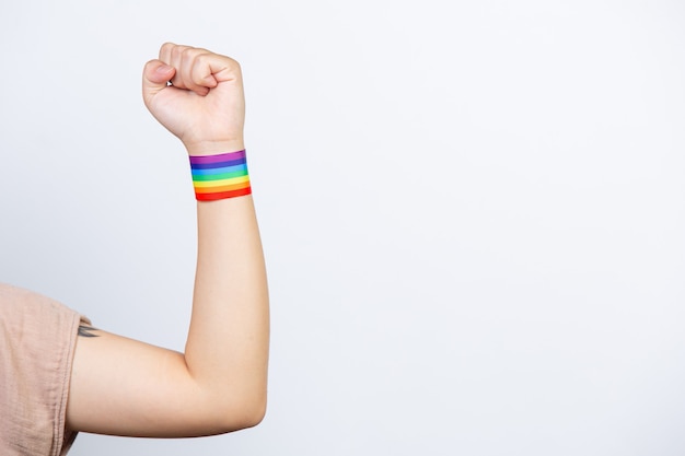 Mujer feliz con pulsera arcoiris LGBT.