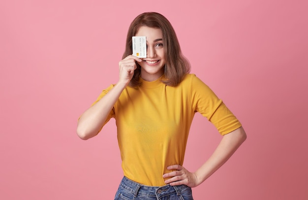 Mujer feliz que muestra la presentación de la tarjeta de crédito para realizar el pago o pagar la confianza comercial en línea