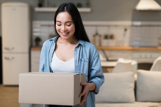 Mujer feliz que sostiene la caja con pedido en línea