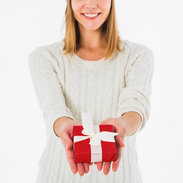 Mujer feliz que sostiene la caja de regalo roja en manos