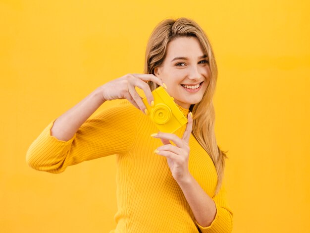 Mujer feliz que sostiene la cámara