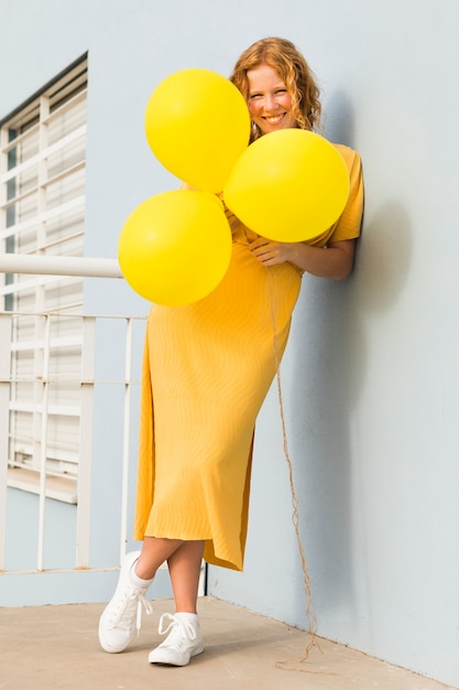 Mujer feliz que sostiene los globos