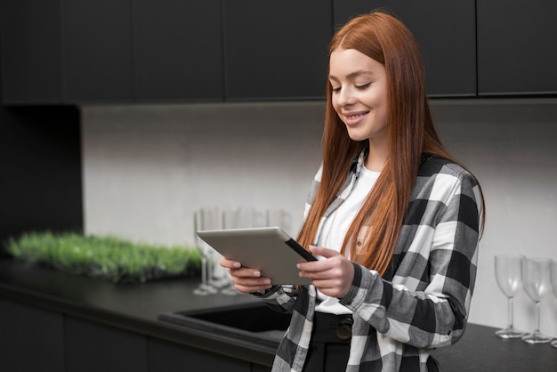 Mujer feliz que sostiene el ipad