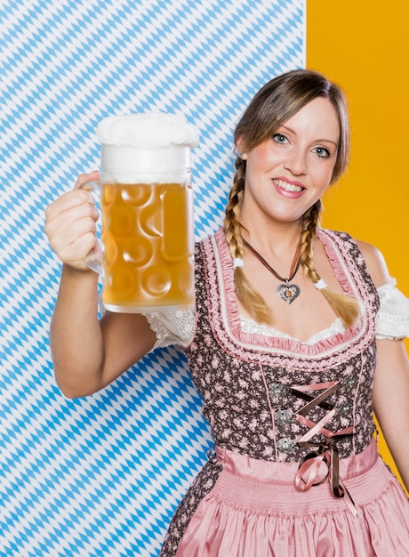 Mujer feliz que sostiene la jarra de cerveza
