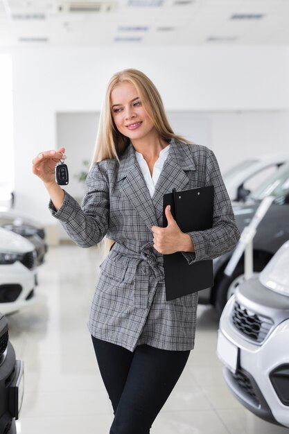 Mujer feliz que sostiene las llaves del coche