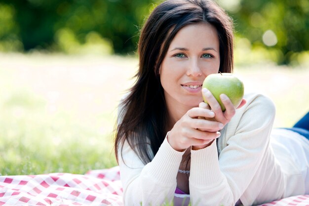 Mujer feliz que sostiene la manzana verde