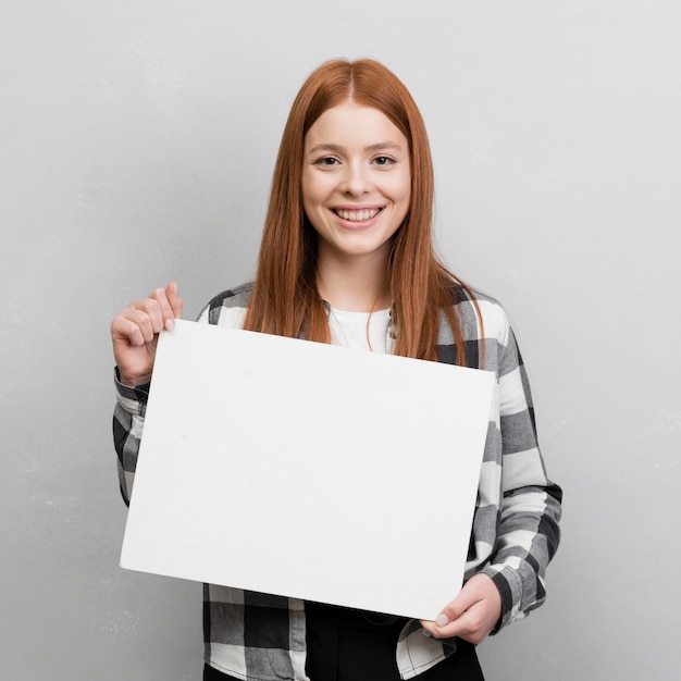 Mujer feliz que sostiene la tarjeta en blanco