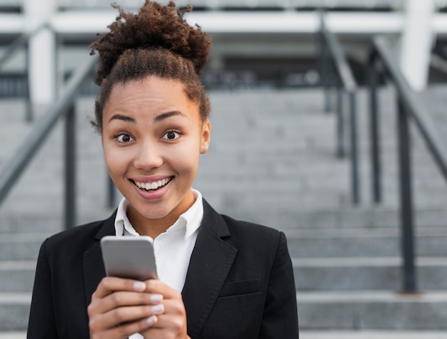 Foto gratuita mujer feliz que sostiene el teléfono