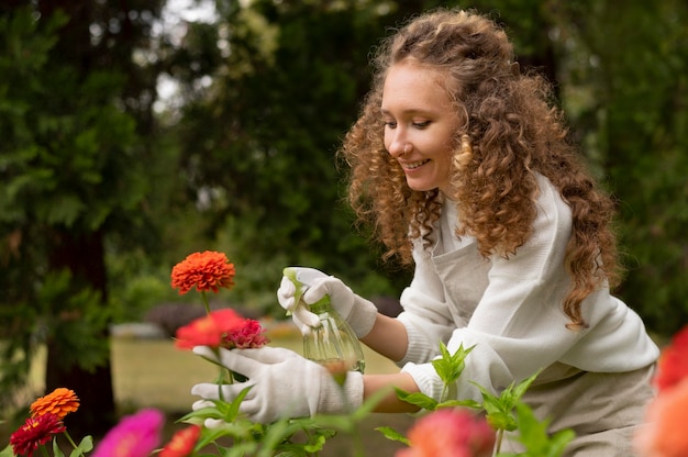 Mujer feliz regando flor tiro medio