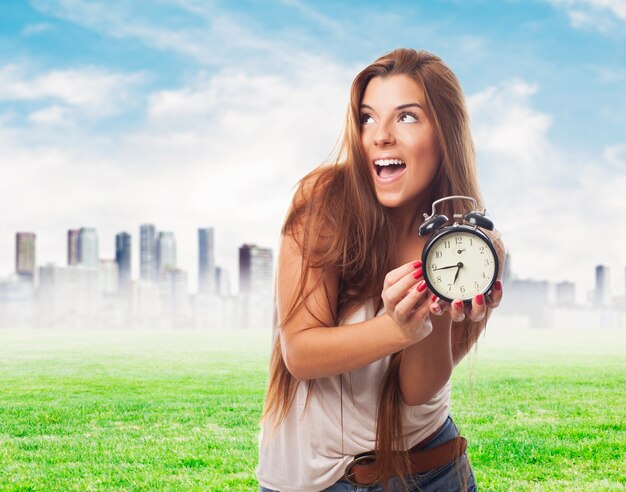 Mujer feliz con el reloj de alarma