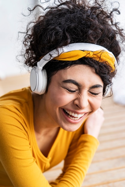 Mujer feliz riendo y escuchando música en auriculares