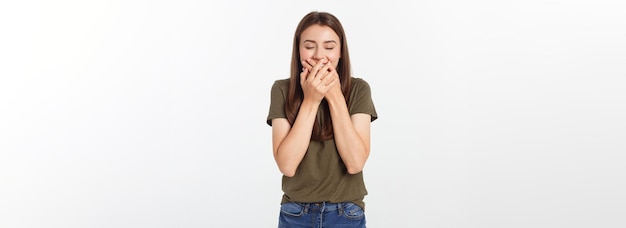 Mujer feliz riéndose cubriendo su boca con un aislado de manos sobre fondo gris