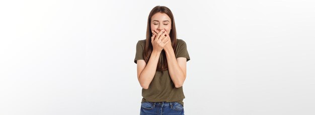 Mujer feliz riéndose cubriendo su boca con un aislado de manos sobre fondo gris