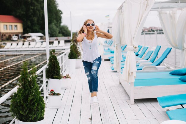 Mujer feliz saltando a lo largo del muelle