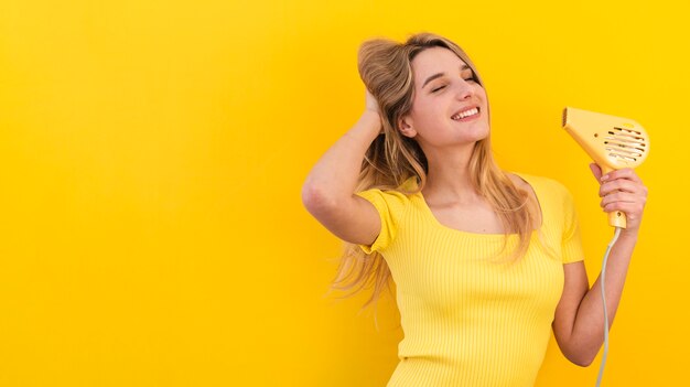 Mujer feliz secándose el pelo