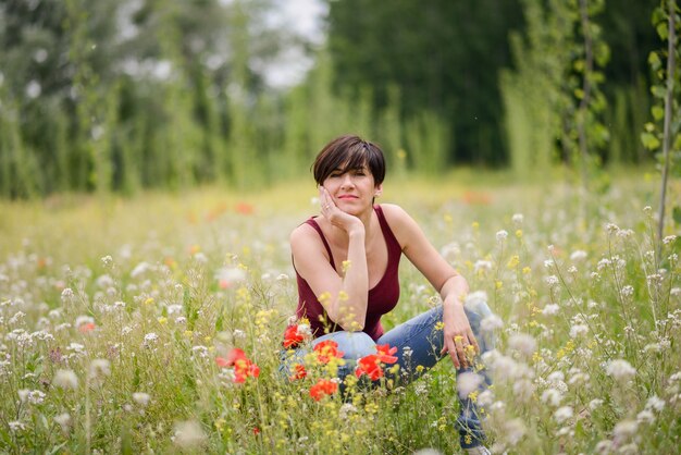 Mujer feliz sentada en medio del prado