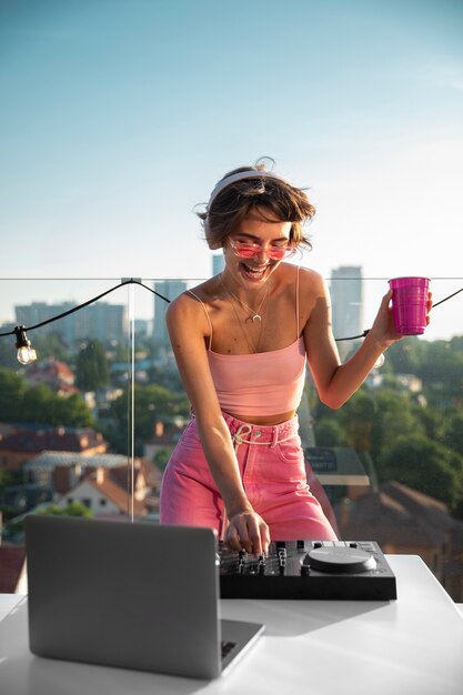 Mujer feliz siendo dj en la vista frontal de la fiesta