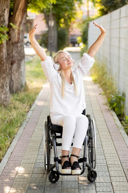 Mujer feliz en silla de ruedas con auriculares