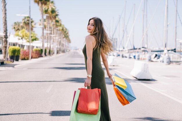 Mujer feliz bajo el sol tras las compras 