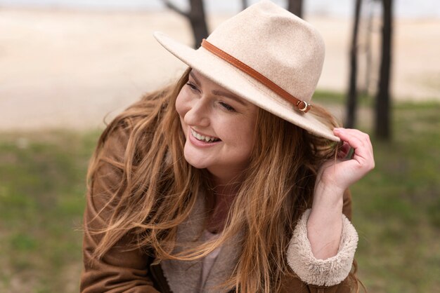 Mujer feliz con sombrero de tiro medio