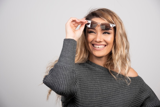 Mujer feliz sonriendo con anteojos.