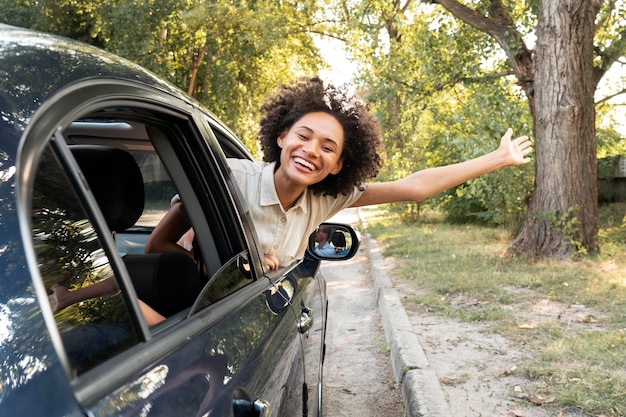 Foto gratuita mujer feliz sonriente en un coche
