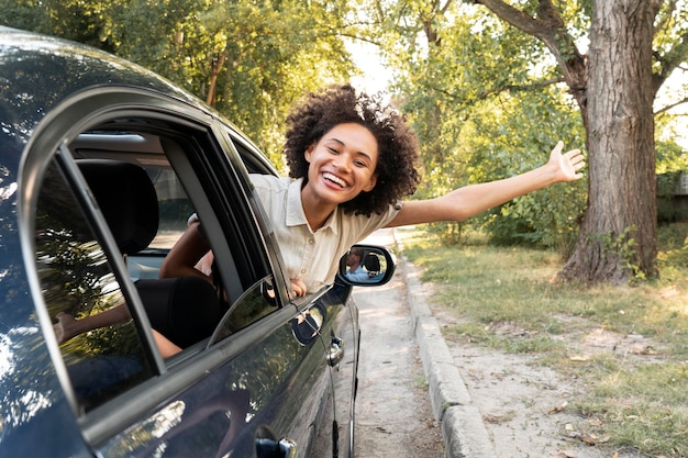 Mujer feliz sonriente en un coche