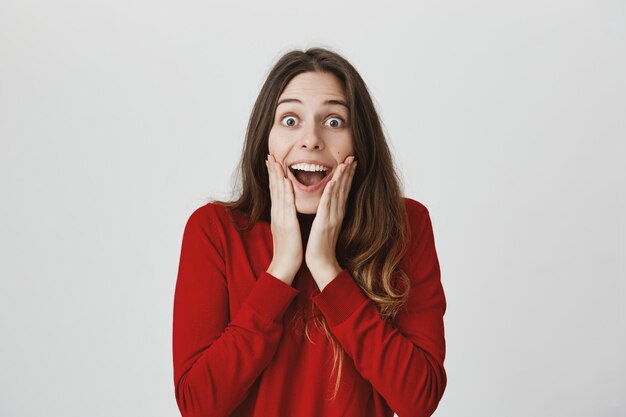 Mujer feliz sorprendida escuchar buenas noticias, sonriendo y jadeando asombrado